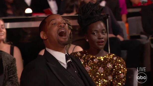Lupita Nyong'o sitting next to Will Smith during Oscar Award gala on March 27th 2022.