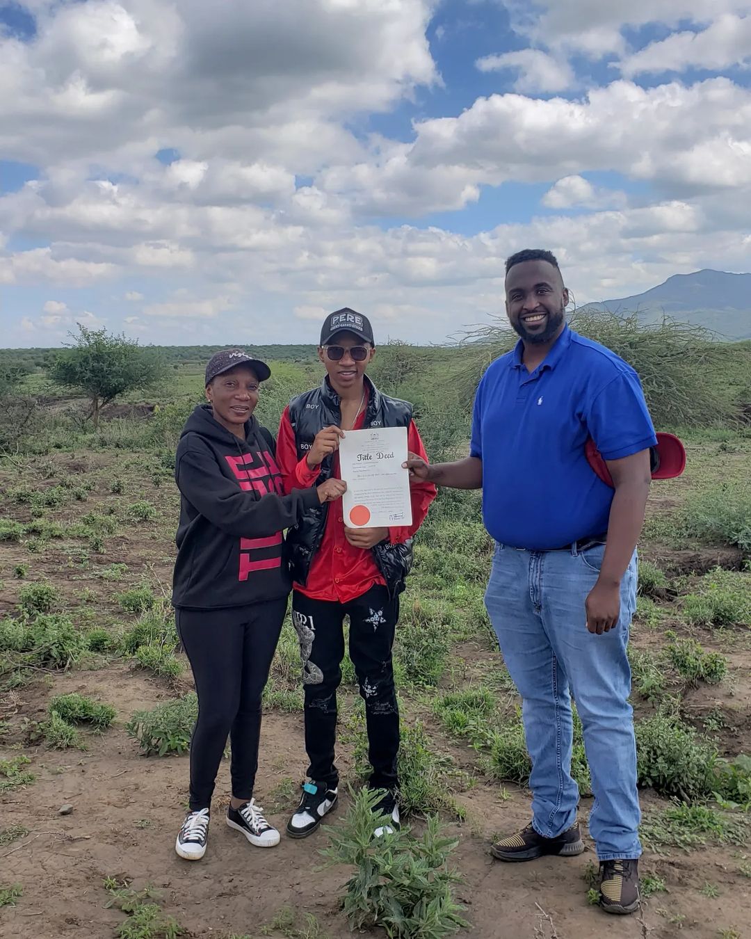 Trio Mio with his mother after he got title deed for a parcel of land he acquired. 